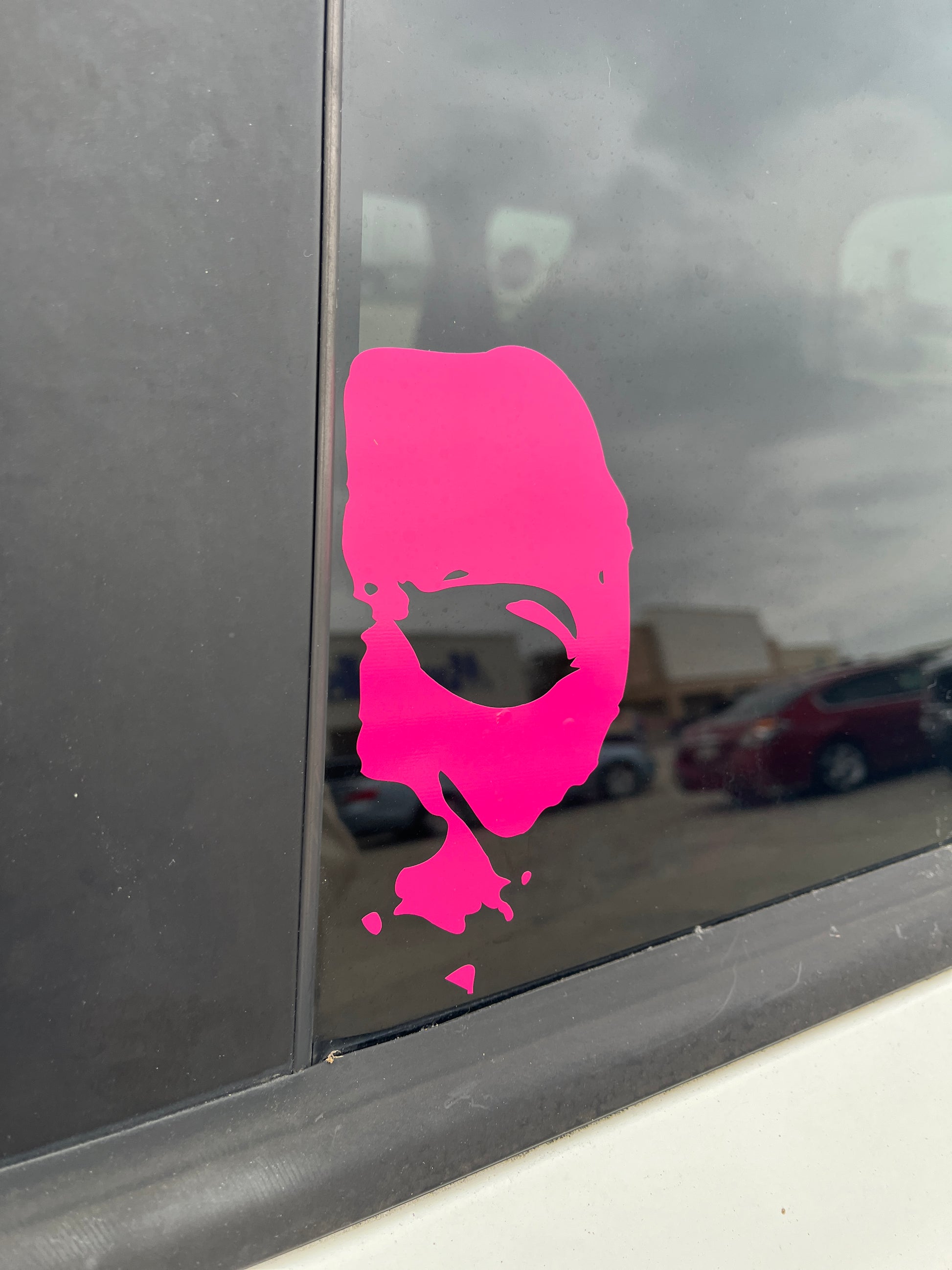 Hot pink Michael Myers decal peeking out from a car window